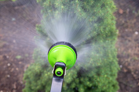 gardener watering the garden with Hose nozzleの写真素材