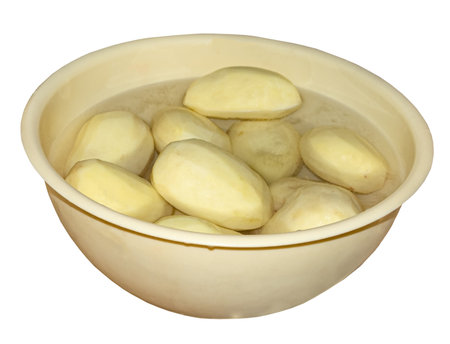 Plastic container with potatoes peeled, cut and filled with water for frying.の写真素材