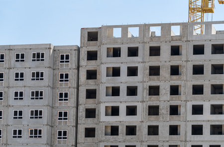 Building crane and building under construction against blue skyの写真素材