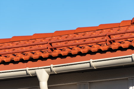A building with red metal tiles on a blue sky background