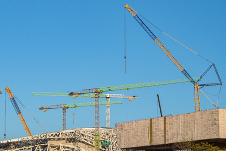 Mounting of metal structures by construction cranes on a construction site against the background of...