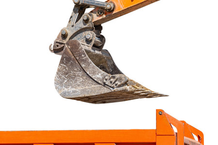 Excavator bucket with soil for loading into a truck on white backgroundの写真素材
