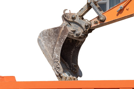 Excavator bucket with soil for loading into a truck on white background