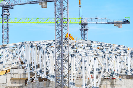 Mounting of metal structures by construction cranes on a construction site against the background of...