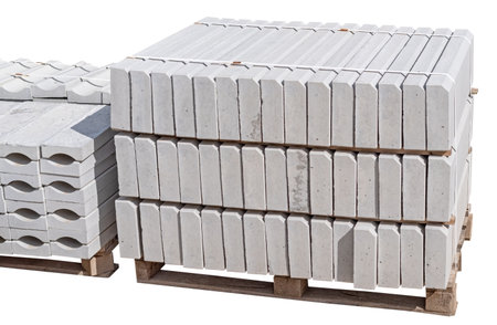 The pallet with a stack of concrete curbstone on white backgroundの写真素材