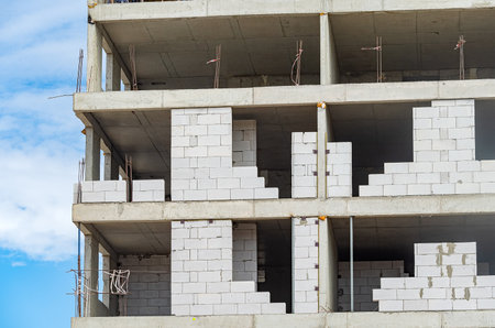 The facade of modern residential building under construction. The construction of modern apartment buildingsの写真素材