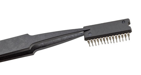 Tweezers hold a chip on a white background