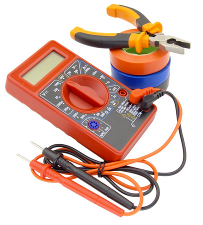 Digital multimeter, pliers and multicolored electrical tape on a white background.