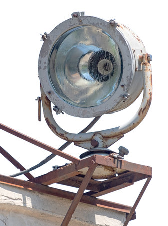 An old spotlight on the roof of a building on white background