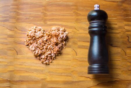 Heart shape in oatmeal with 
Pepper grinder on wooden background. Healthy food conceptの写真素材