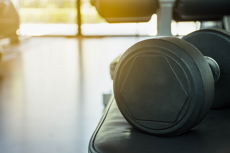 Close up black dumbbells  on fitness center  background.