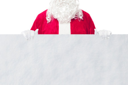 Happy Santa Claus looking out from behind the blank sign isolated on white background with copy spaceの写真素材