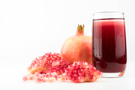 Glass of pomegranate juice with fruit isolated on white.の写真素材