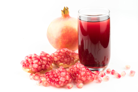 Glass of pomegranate juice with fruit isolated on white.の写真素材