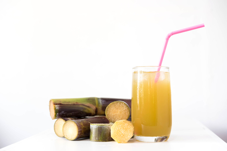 Fresh sugar cane juice in glass on table white backgroundの写真素材