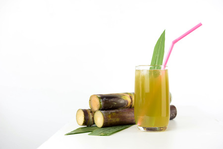 Fresh sugar cane juice in glass on table white backgroundの写真素材