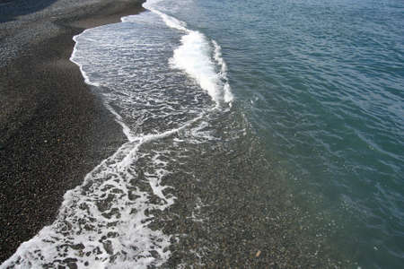 Sea coastline. Pebbles and water.