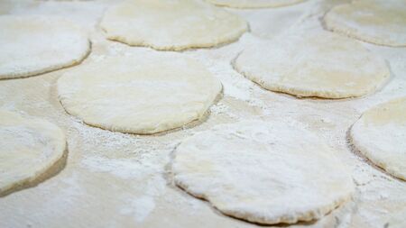 round shape of the dough with flour on the table.の写真素材