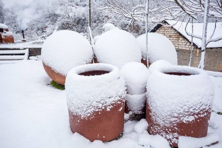Snow covered georgian jugs for wine, outdoor in winter.の写真素材