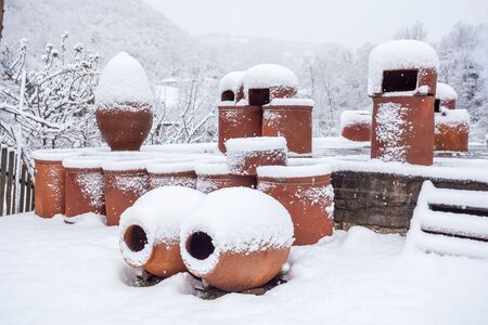 Snow covered georgian jugs for wine, outdoor in winter.の写真素材