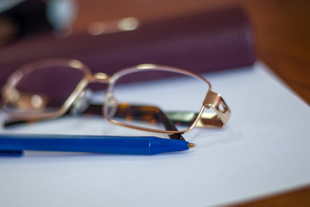 ballpoint pen on a sheet and reading glasses with box.の写真素材