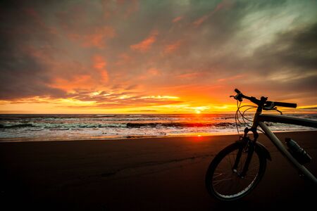Tourist bike on the coast of the sea at sunset time.の写真素材