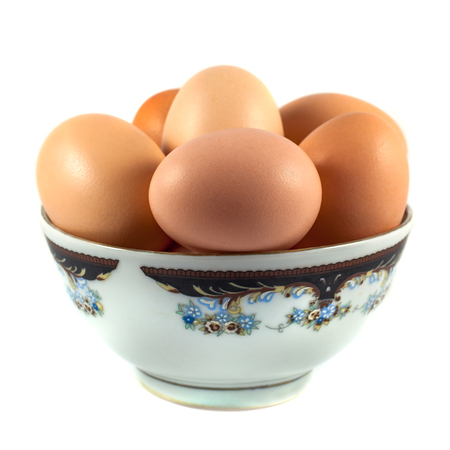 brown chicken eggs in a cup isolated on white.の写真素材
