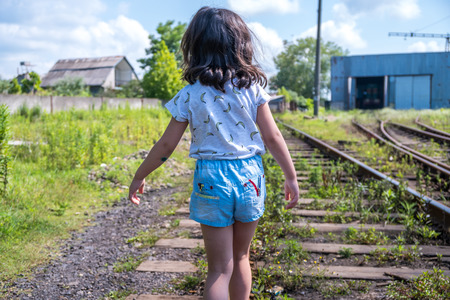Little girl go on rails, back to a camera.の写真素材
