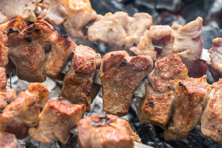 Cooking shashlik in the forest. Grilling pork on coal with smoke, mtsvadi, barbecue.の写真素材