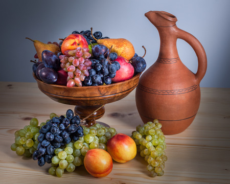 autumnal fruit still life with Georgian jug on rustic wooden table background.の写真素材
