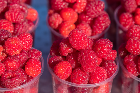 A lot of raspberries on the street market counter.の写真素材