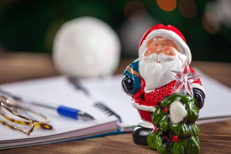 Hands with a pen, notebook and an envelop for letter. A girl is ready to write a letter to Santa Claus. dreams come true, magic holidays and merry Christmas, gifts timeの写真素材