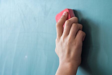 girls hand in elementary school cleaning board with sponge.