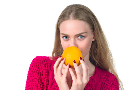 Beautiful portrait of young woman with orange. Healthy food concep.の写真素材