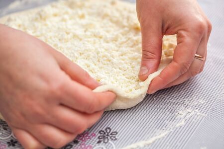 Baker hands preparing khachapuri on kitchen table. View on cook making traditional georgian treat...