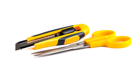 Yellow scissors and cutter knife isolated on white background.の写真素材