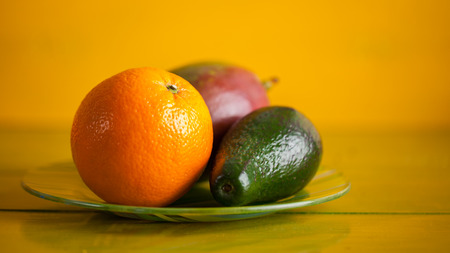 Tropical fruit on the table on yellow wooden background. Fresh food.の写真素材