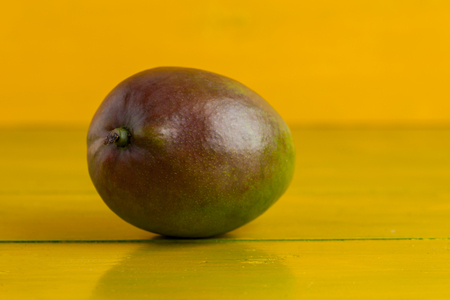 Mango on the yellow wooden table, fresh food.の写真素材