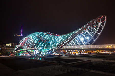 Pedestrian bridge of peace over the Mtkvari (Kura) River in Tbilisi at night. Georgian flag.のeditorial素材