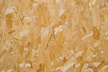 close up pressed wooden panel background, seamless texture of oriented strand board - OSB wood.