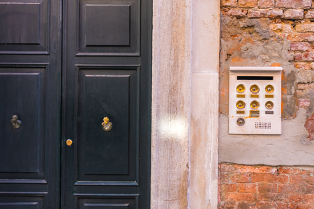 Ancient intercom in Venice with golden buttons, Italy.