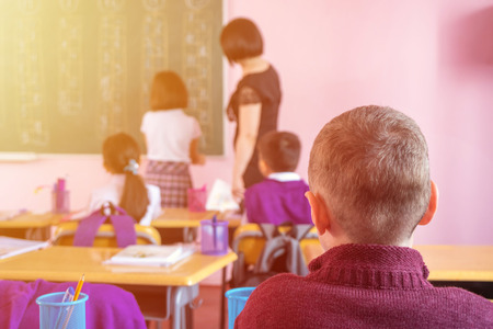 children actively participate in the class, read and listen to the teacher.の写真素材
