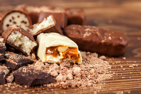 Various yummy chocolate candies on wooden table, sweets.の写真素材