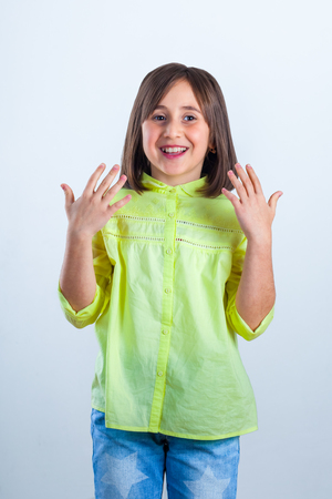 little girl in yellow shirt posing for the camera in the studio.の写真素材