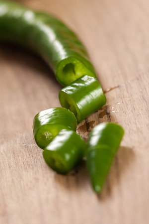 sliced green peppers on a wooden board.の写真素材