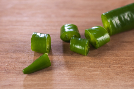 sliced green peppers on a wooden board.の写真素材