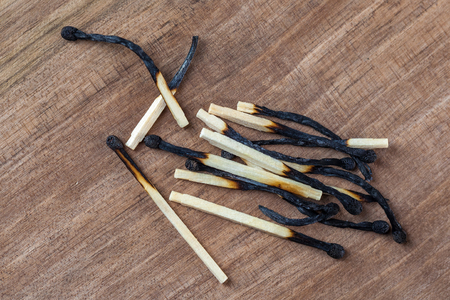Burned wooden matches sticks on a wooden table background.の写真素材
