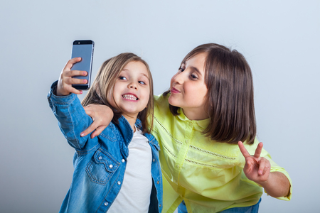 two sisters posing and taking selfies in the studio.の写真素材