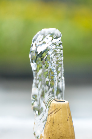 Close up water drops flowing from fountain.の写真素材