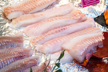 Fresh chilled out fillets of white fish on the counter of ice. fresh food.の写真素材